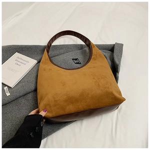 Detail view of brown suede shoulder bag showing stitching and premium leather textures