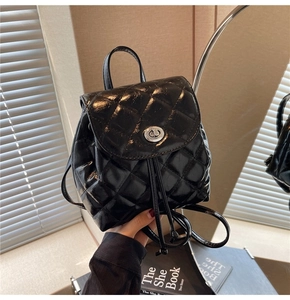 Détail d'un mini sac à dos matelassé noir avec fermoir tournant en métal argenté