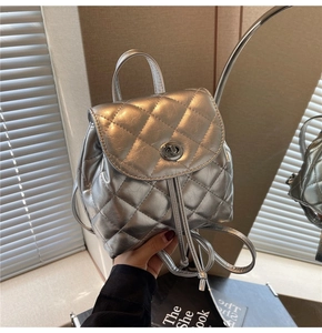 Détail d'un mini sac à dos argenté avec matelassage et verrou tournant métallique