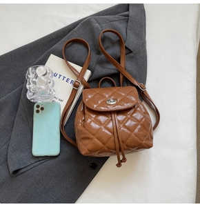 Détail d'un mini sac à dos marron matelassé avec fermoir rotatif en métal et cordon
