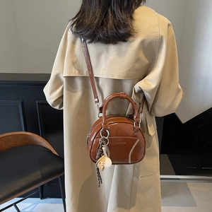 Vintage brown bowling bag with white baseball stitching and crossbody strap