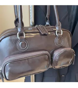Detail of dark brown vintage bowling bag with dual front zipper pockets and silver hardware