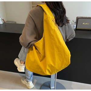 Close-up of bright yellow lightweight puff shoulder bag with high-quality nylon texture