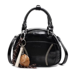 Retro black bowling bag with baseball stitching and charms on a white background