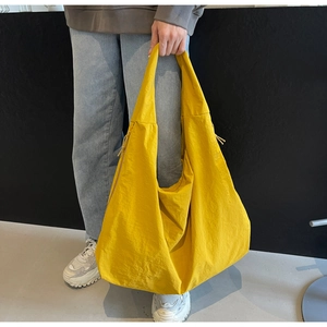 Detailed shot of yellow puffy tote bag made of lightweight parachute nylon fabric