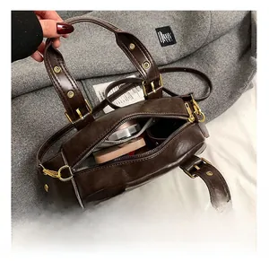 Macro view of interior storage space and zipper pocket in a dark brown leather shell bag