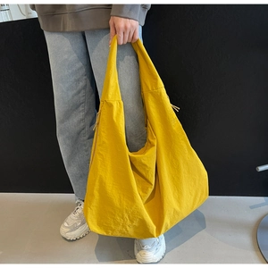 Close-up of lightweight lemon yellow puffy tote bag with side drawstring detail