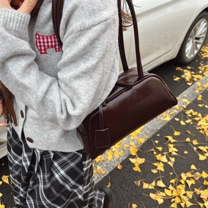 Retro chocolate brown leather Boston bag with slim shoulder straps in an autumn setting