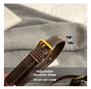 Detail show of adjustable brown leather shoulder strap with gold metal buckle hardware
