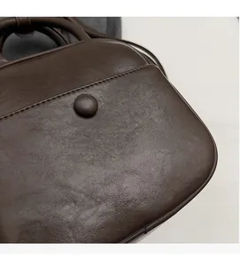 Macro detail of soft lychee-patterned dark brown PU leather with fine stitching