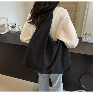 Detailed view of the large black nylon hobo bag featuring a zipper and soft knotted detail