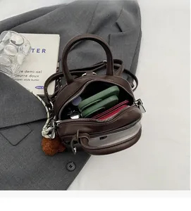 Top view of deep brown matte leather mini handbag with spacious interior and slim strap
