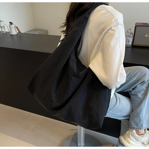 Detail of black puffer tote bag made of ultra-light parachute nylon with drawstring