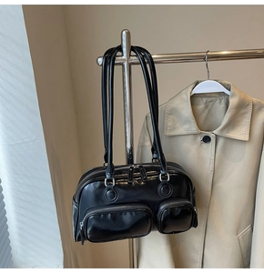 Detail of vintage black oil wax leather shoulder bag showing front zipper pockets and texture