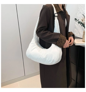 Détail d'un sac à bandoulière matelassé blanc avec sangle réglable et texture minimale