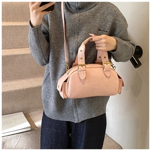 Detail view of pink vintage bowling bag with side pockets and gold buckle accents