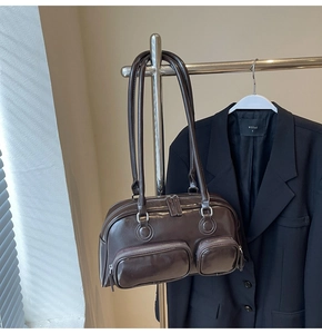 Detail of dark brown oil wax leather shoulder bag with triple zipper pockets