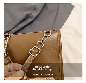 Detail of adjustable shoulder strap with silver hardware and textured brown leather