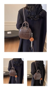 Close-up of retro brown PU leather backpack with dual handles and bear charm detail