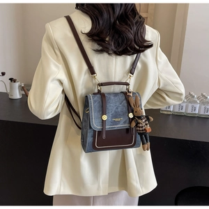 Detail eines Retro-Mini-Rucksacks aus Denim und Leder mit süßem Hasenanhänger am Model