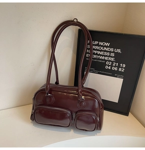 Detailed view of the dark burgundy oily leather handbag with stylish zipper pockets
