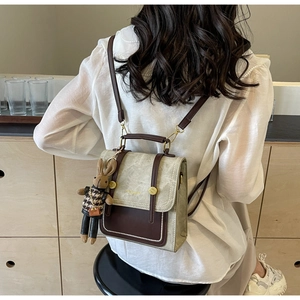 Detailansicht eines kontrastfarbenen Rucksacks mit Vintage-Schloss und Hasen-Anhänger