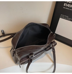 Macro detail of dark brown oil wax leather shoulder bag with multiple zipper pockets