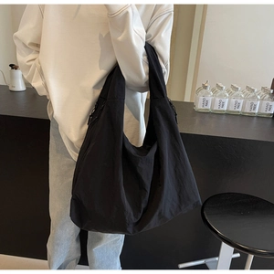 Detail of black parachute fabric hobo bag showing large capacity and drawstring side