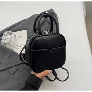 Minimalist black mini backpack for women with silver zippers and elegant hand strap