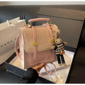 Detail von rosa und beige Patchwork-Rucksack mit Metallakzenten und Kaninchen-Plüschanhänger