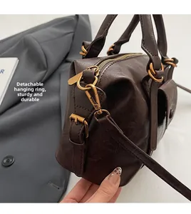 Detail of durable gold metal hook and lychee textured brown PU leather dumpling bag