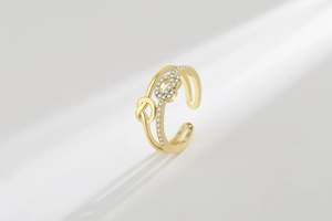 Close-up of dual-layer twisted gold open ring featuring micro-pave white zircon stones