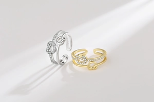 Detail of stacked gold and silver knot rings with pavé zircon stones on grey background