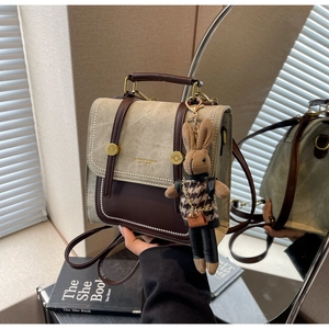 Detail der Retro-Kontrastnähte und goldenen Nieten an einem minimalistischen Rucksack