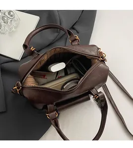 Interior detail of a dark brown dumpling bag showing spacious capacity for daily items