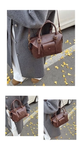Detail of vintage brown pleated boston bag with lychee texture and adjustable strap