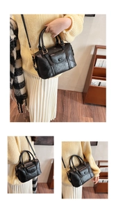 Detail of black vintage textured leather pillow bag with gold metal buckle and strap