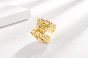 Detailed close-up of a golden spider ring featuring intricate embossed textures and textures