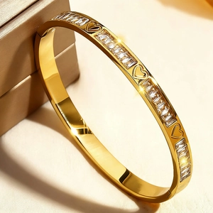 Détail du bracelet doré en acier inoxydable avec zircons et motifs de cœurs évidés