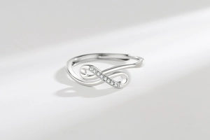 Detail of silver infinity ring featuring small zircons and adjustable open band design