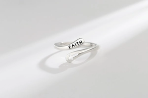 Macro shot of silver ring featuring engraved FAITH text and hollow cross detail