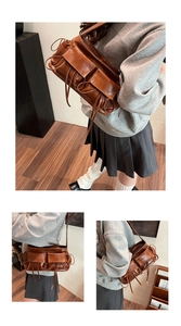 Detailed view of brown multi-pocket hobo bag with long drawstrings and workwear aesthetic