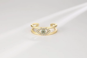 Detail of 18K gold open ring featuring a double-layered hollow evil eye with blue stones