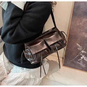 Detail of dark brown vintage shoulder bag with multiple pockets and decorative drawstrings