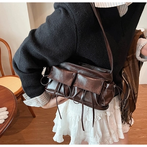 Close-up of vintage brown gloss leather shoulder bag with pockets and tassel details