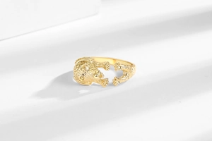 Macro d'une bague dorée ajustable avec motif 3D de tête de chiot et petites pattes