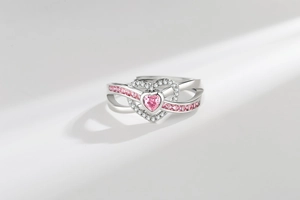 Detailed view of heart-shaped pink gemstone ring with pavé zircons and spiral band