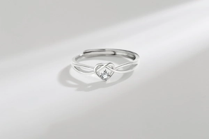 Macro shot of silver heart-shaped adjustable ring with sparkling round zircon center