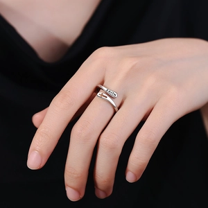 Double-layer silver cross ring with FAITH engraving worn on finger, adjustable open design