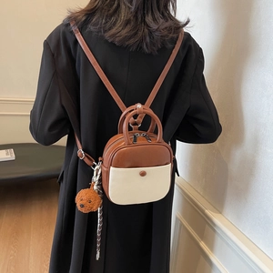 Minimalist two-tone brown and beige leather mini backpack with cute bear pendant